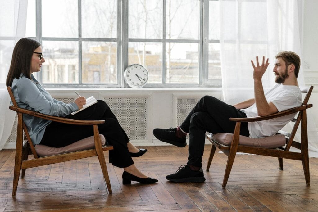 4101143 A therapist engaging in a counseling session with a male patient to support mental health.