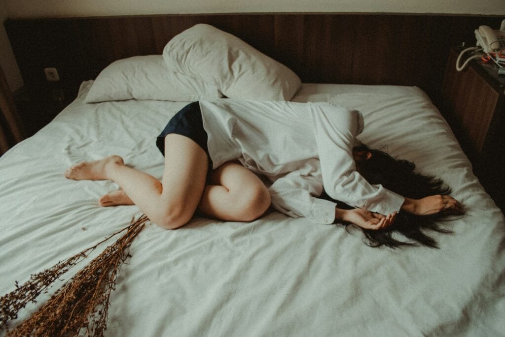 woman lying on bed showing she is facing depression.
